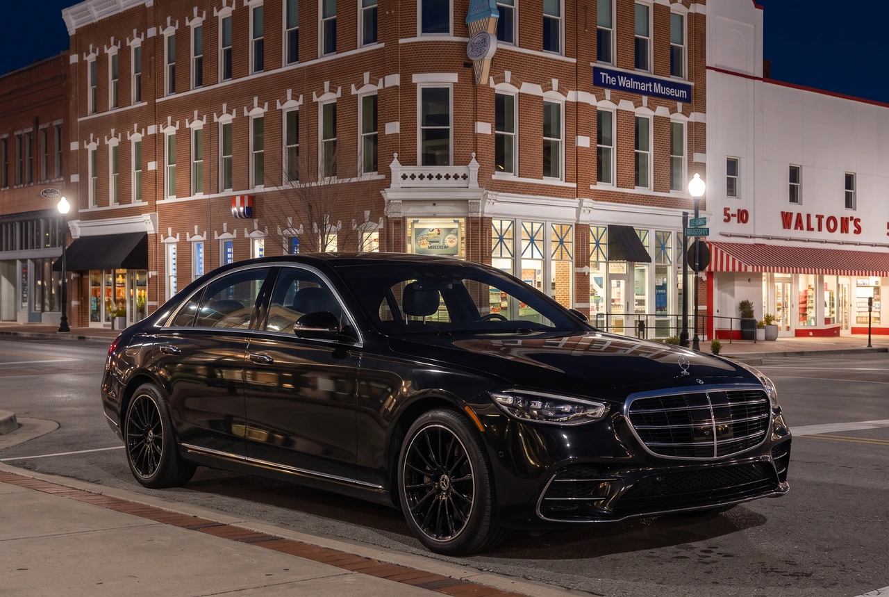 Uploaded black Mercedes-Benz S 580 4MATIC in an AI-edited nighttime setting beside Bentonville's Walmart Museum